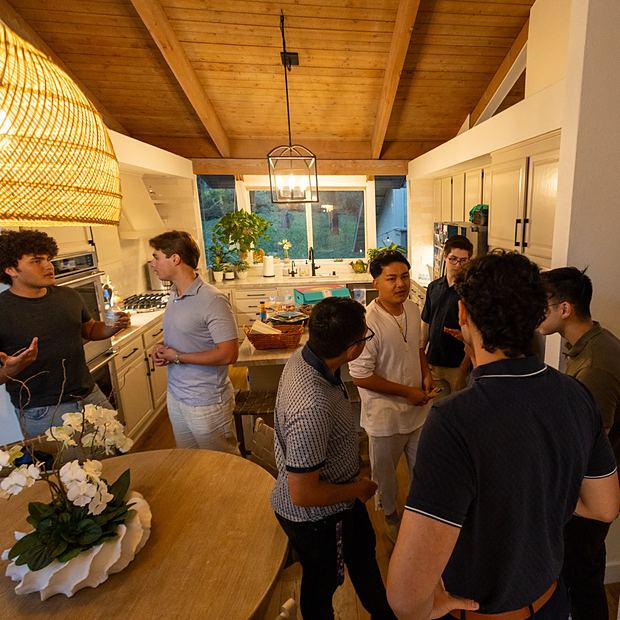 Members talking in a kitchen before a meeting