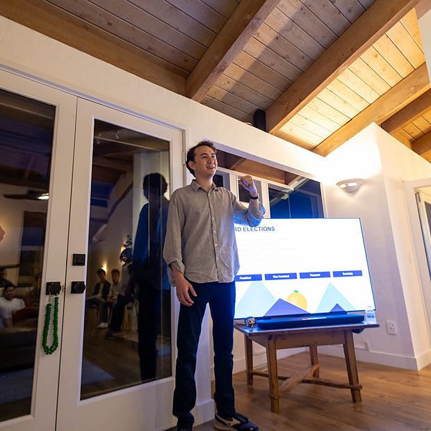 A member presenting to the group beside a screen